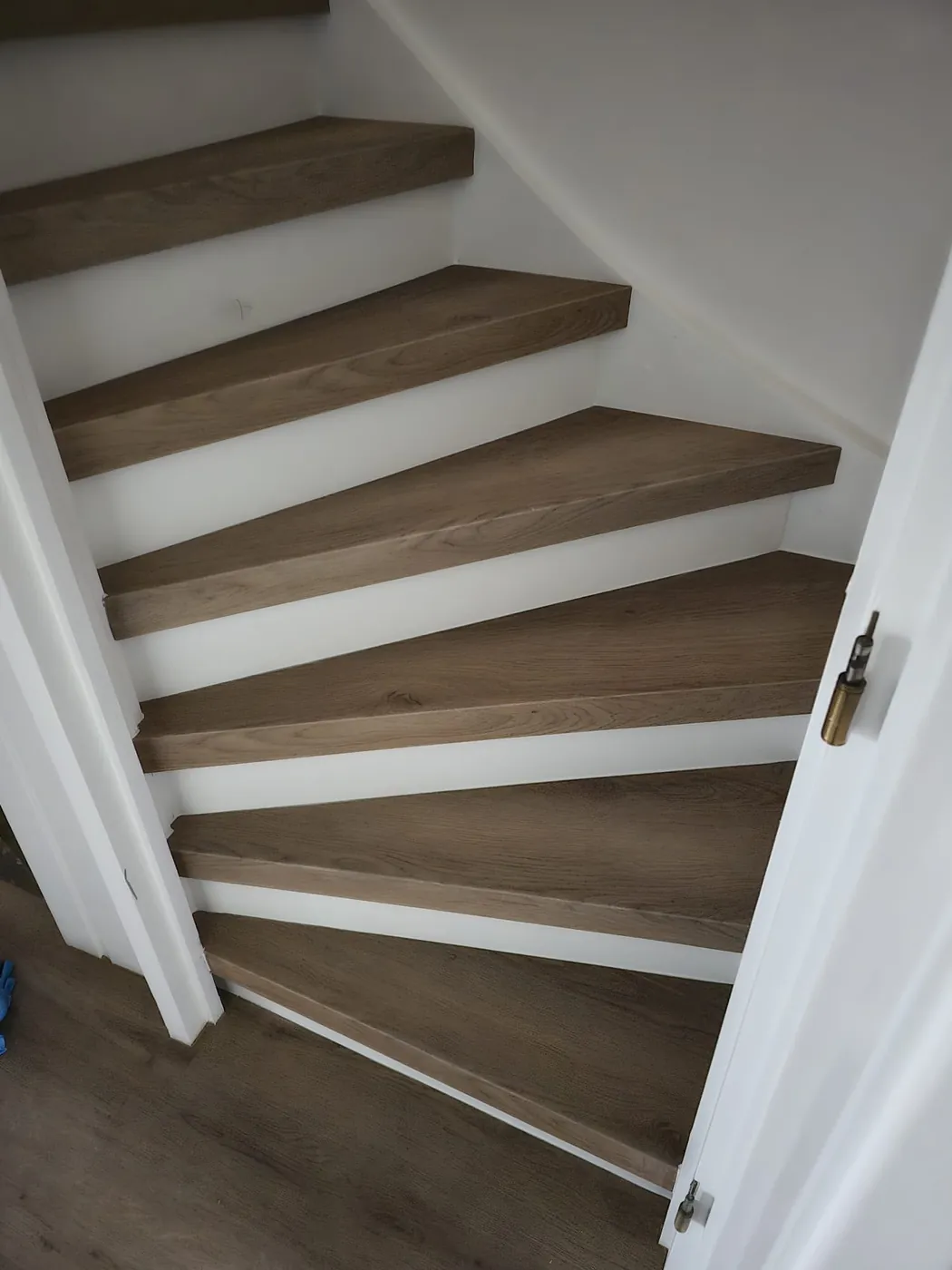 Trap met houtlook treden en witte stootborden in een bocht