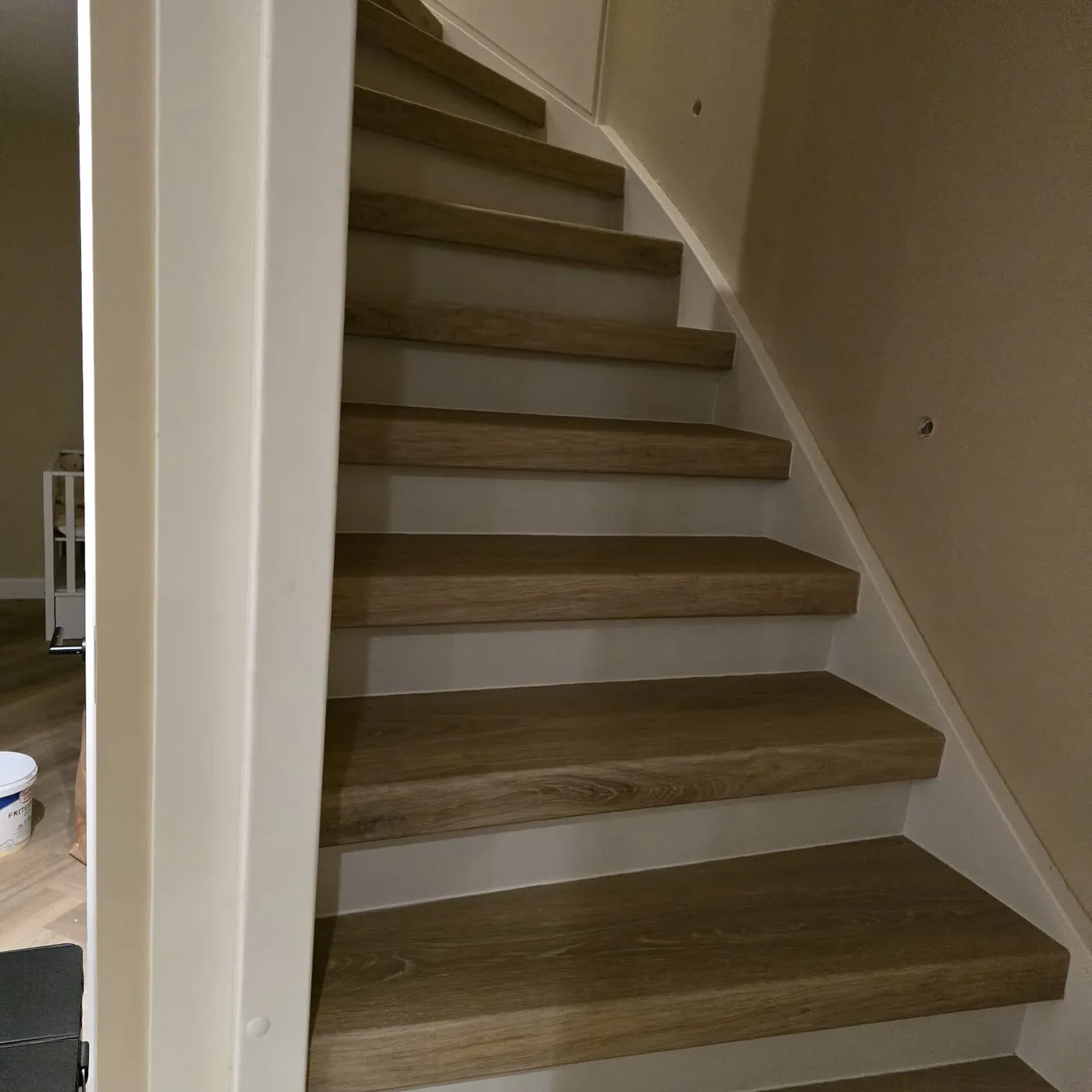 Trap met bruine houtlook treden en witte stootborden