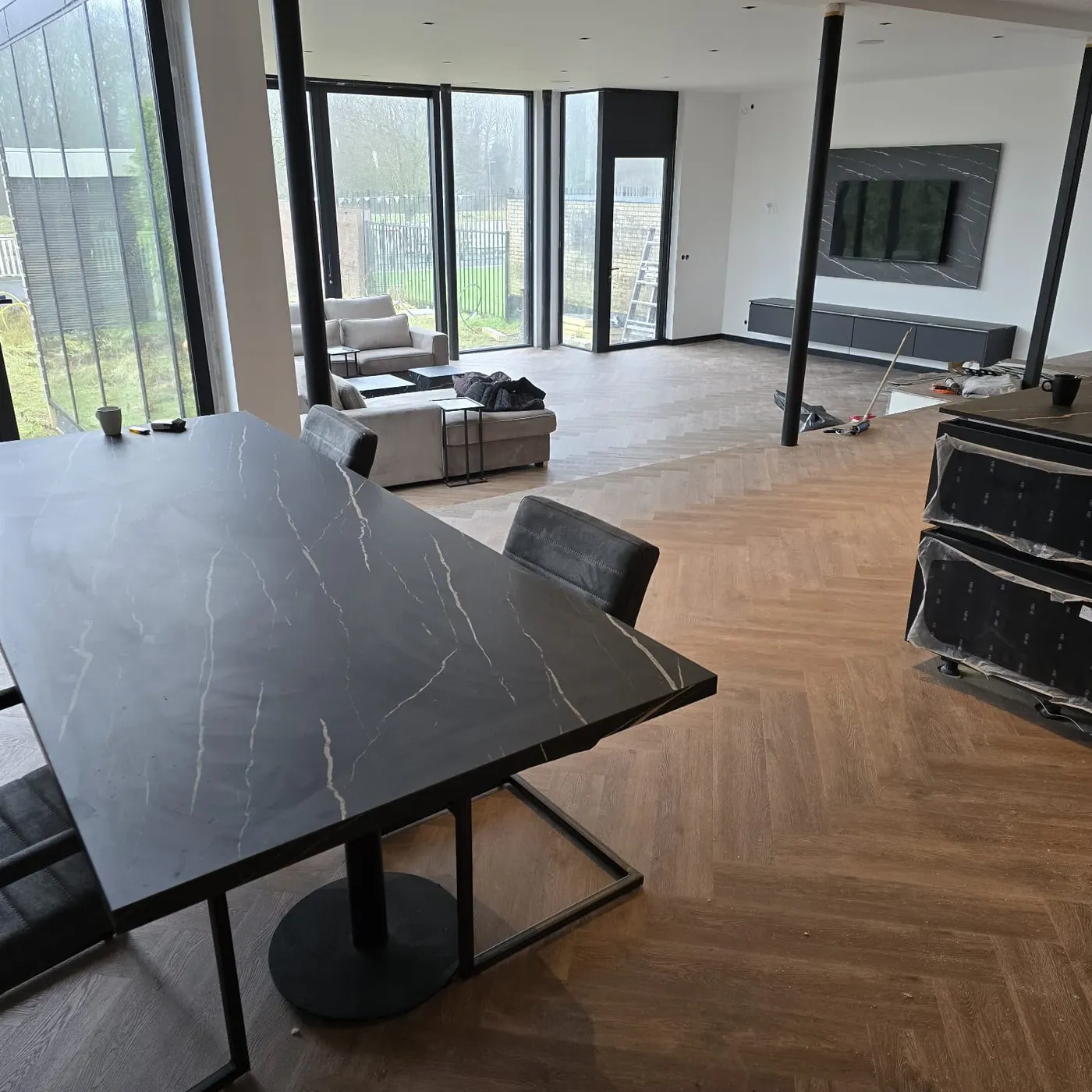 Woonkamer met een visgraatvloer en een eettafel